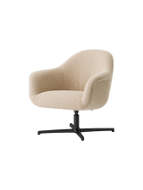 Angled view of the Harbour Lounge Chair with a textured, light beige upholstered shell and a black, star-shaped swivel base.